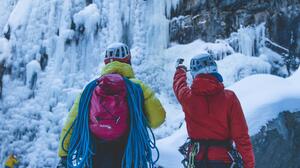 Personnes de dos qui s'apprêtent à escalader une cascade de glace